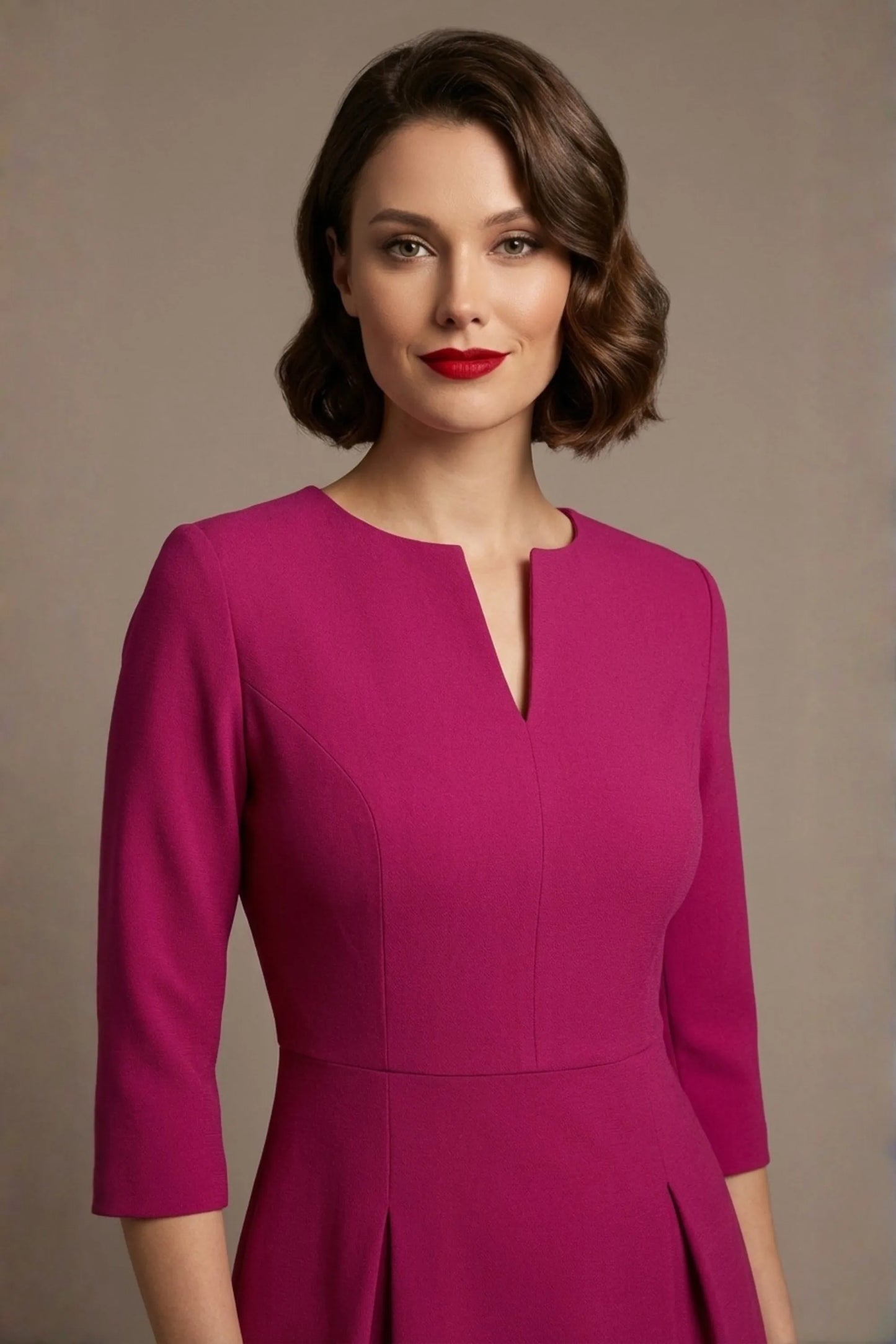 Woman wearing a diva catwalk Amanda Pleated a-line dress in a magenta pink colour against a beige background (Magenta)