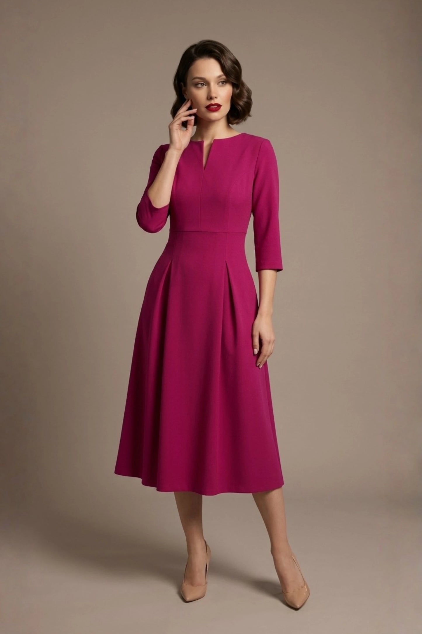 Woman wearing a diva catwalk Amanda Pleated a-line dress in a magenta pink colour against a beige background (Magenta)