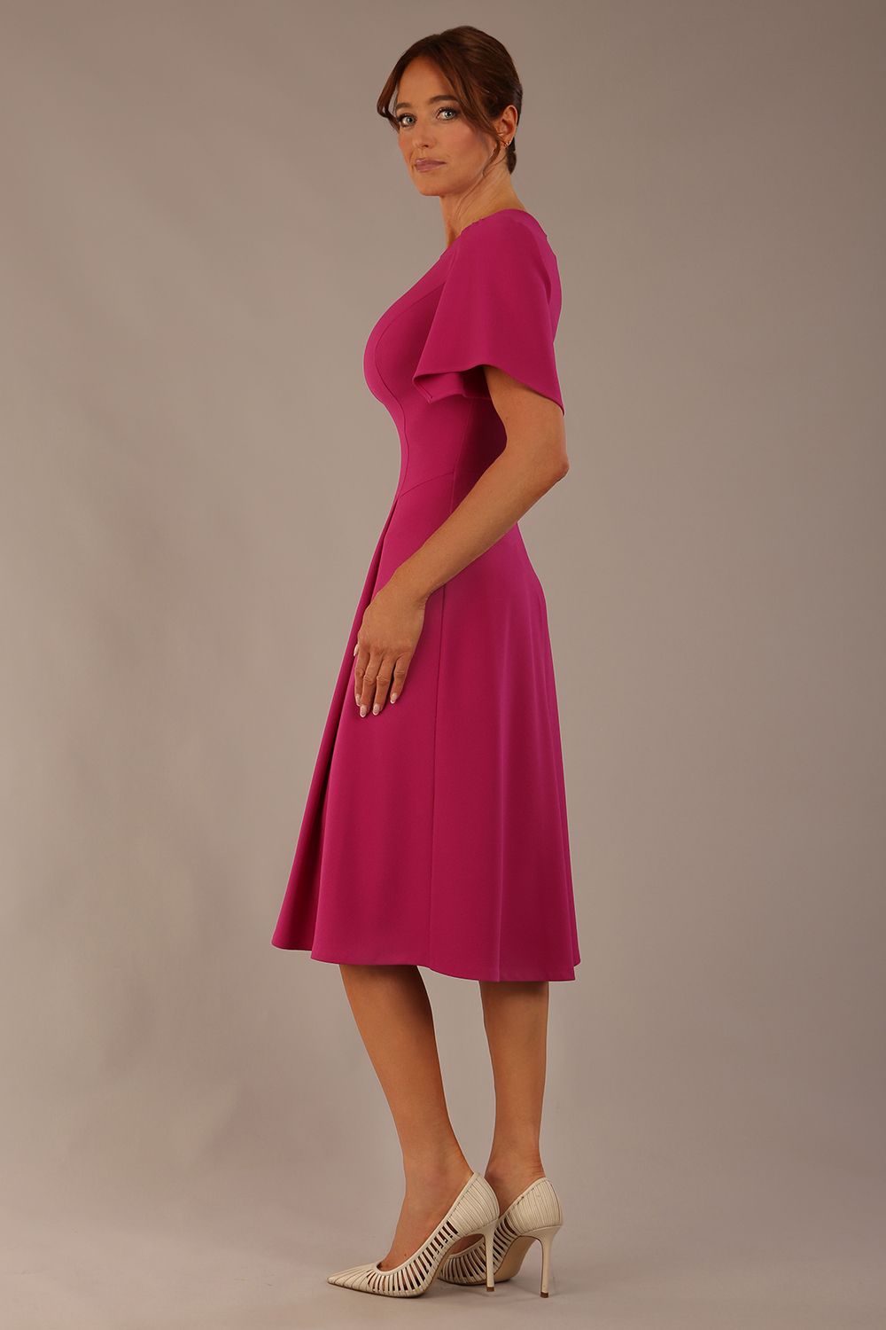 side view Model wearing a diva catwalk Anders petal sleeve A-line dress against a plain background (Magenta)