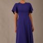 close up Model wearing a diva catwalk Anders petal sleeve A-line dress against a plain background (Spectrum Indigo)