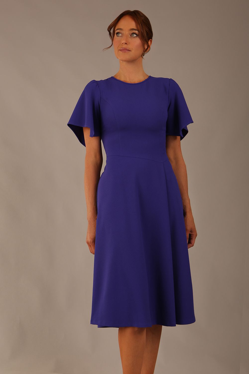 close up Model wearing a diva catwalk Anders petal sleeve A-line dress against a plain background (Spectrum Indigo)