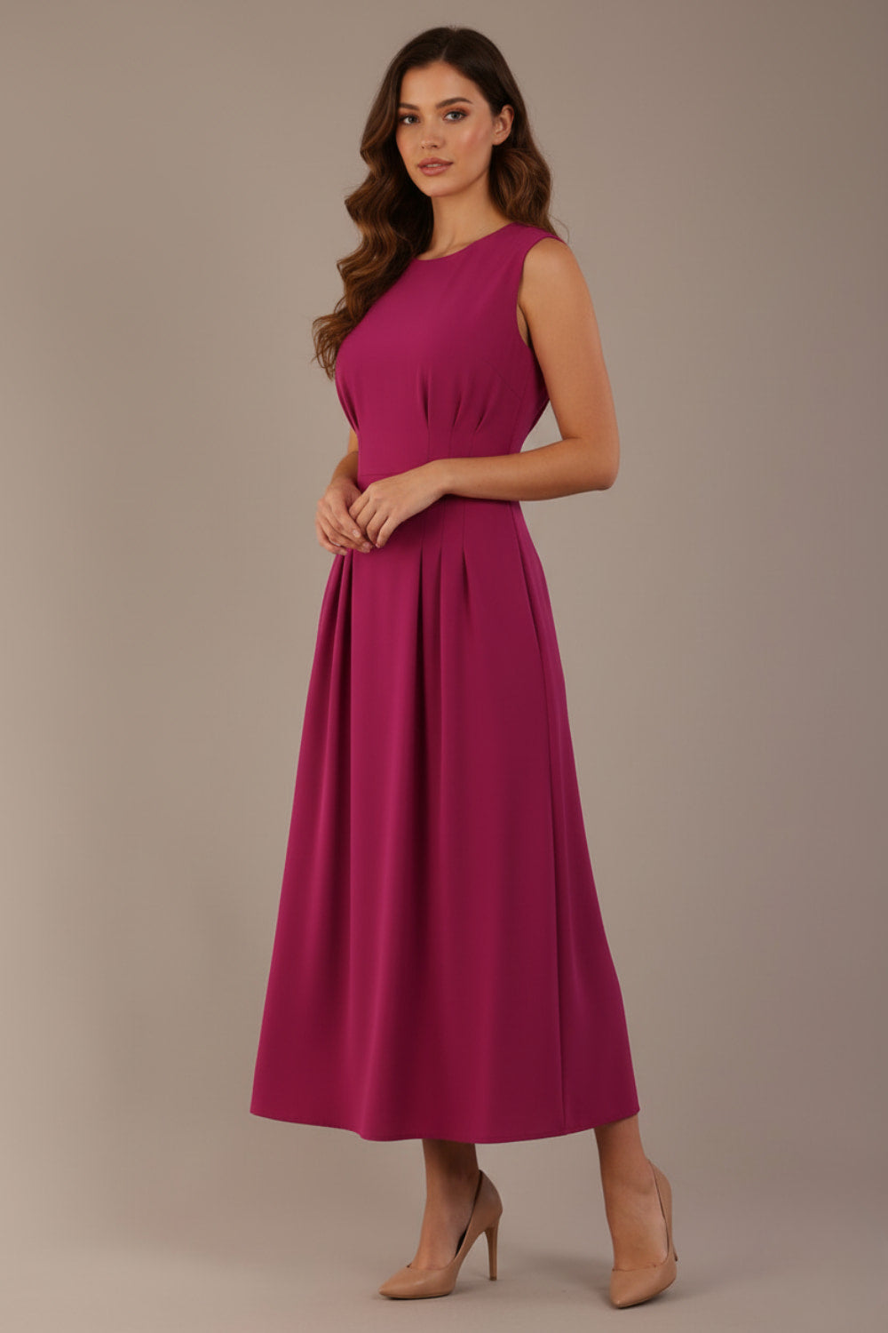 Model wearing the Cleo pleated midaxi dress in magenta with discreet side pockets.