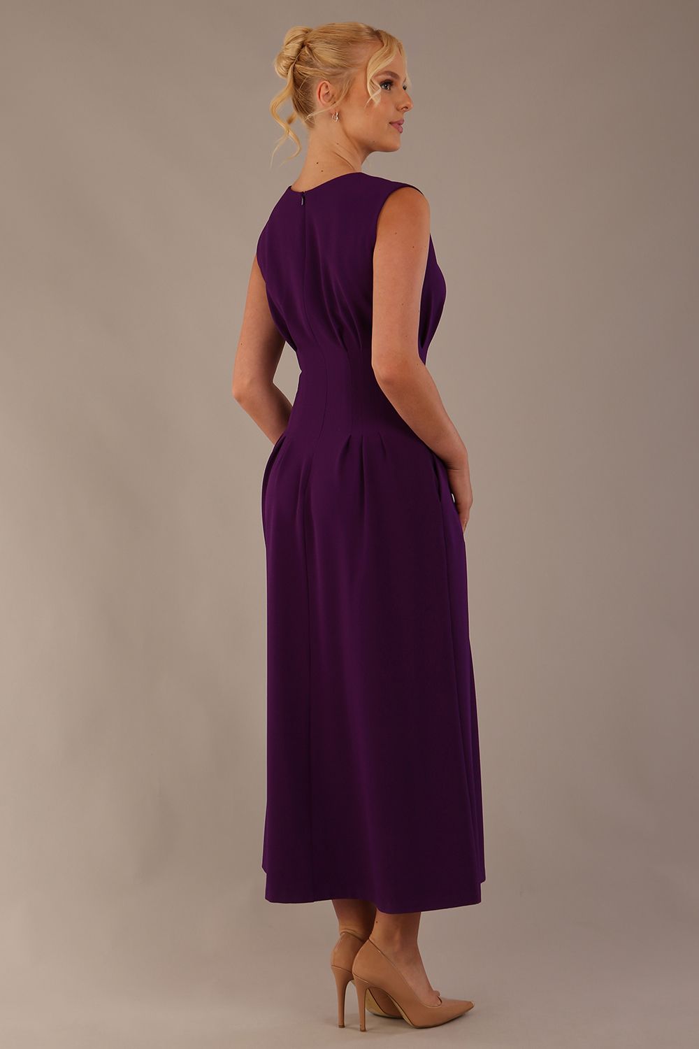 Back view of the Cleo dress in purple, showing the continuation of the pleat detail and A-line skirt.