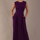 Model wearing the Cleo pleated midaxi dress in purple with hands in the discreet side pockets.