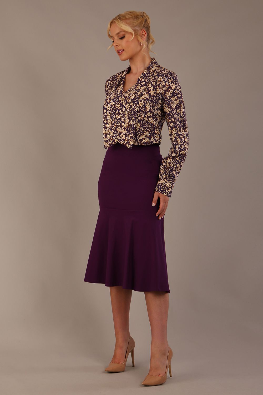 Model wearing the Truro floral top, showing the standard hip-length and draped V-neck and purple marlene skirt against a gray background