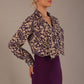 Model wearing the Truro floral top, showing the standard hip-length and draped V-neck and purple skirt against a beige background