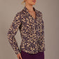 Model wearing the Truro floral top, showing the standard hip-length and draped V-neck and purple skirt against a beige background side view