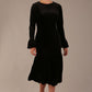 The Sophisticat black velvet dress shown in motion, highlighting the fluted fishtail skirt.