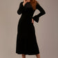 Woman wearing a black sophisticat dress against a plain background (Black Velvet)