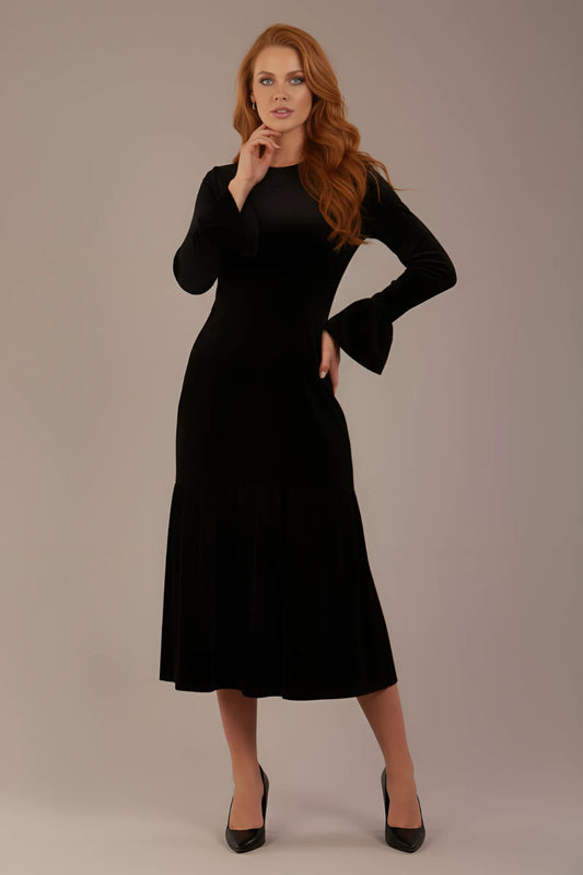 Woman wearing a black sophisticat dress against a plain background (Black Velvet)
