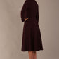 Side profile of the Moneypenny dress, highlighting the fluid movement of the A-line skirt.