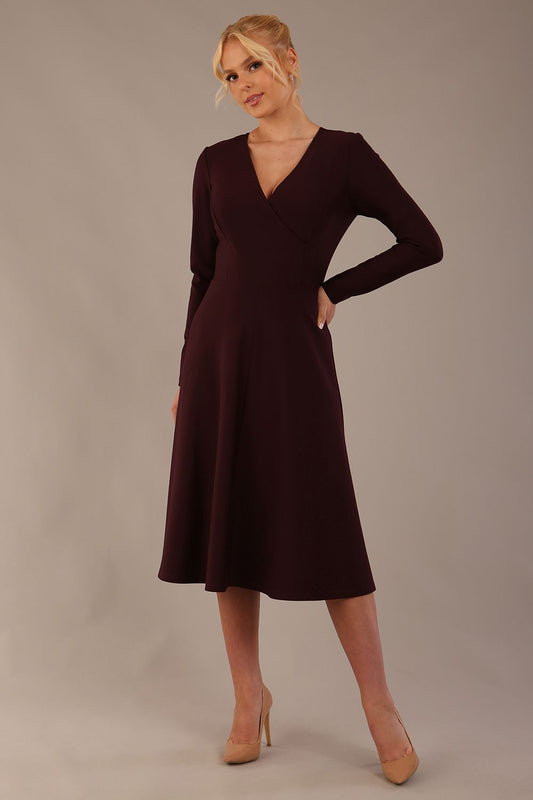 Model wearing the Moneypenny A-line midi dress in decadent fig, showcasing the classic V-neckline.