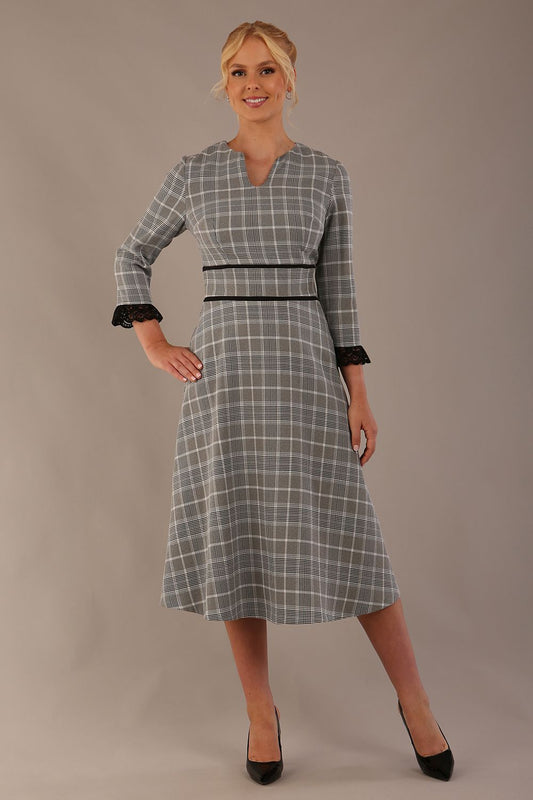 Model wearing the Hendricks check midi dress in misty grey with black lace cuffs and a V-neck.