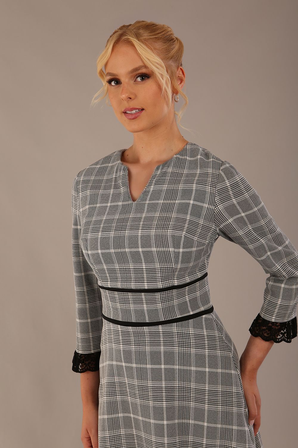 Model wearing the Hendricks check midi dress in misty grey with black lace cuffs and a V-neck.
