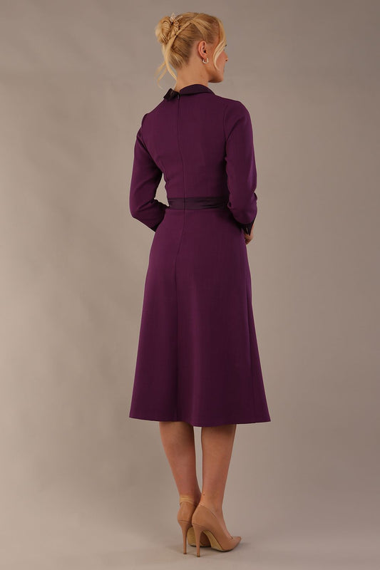 Back view of the Sybil dress in imperial purple, showing the elegant high back with its split satin collar detail. (Imperial Purple)