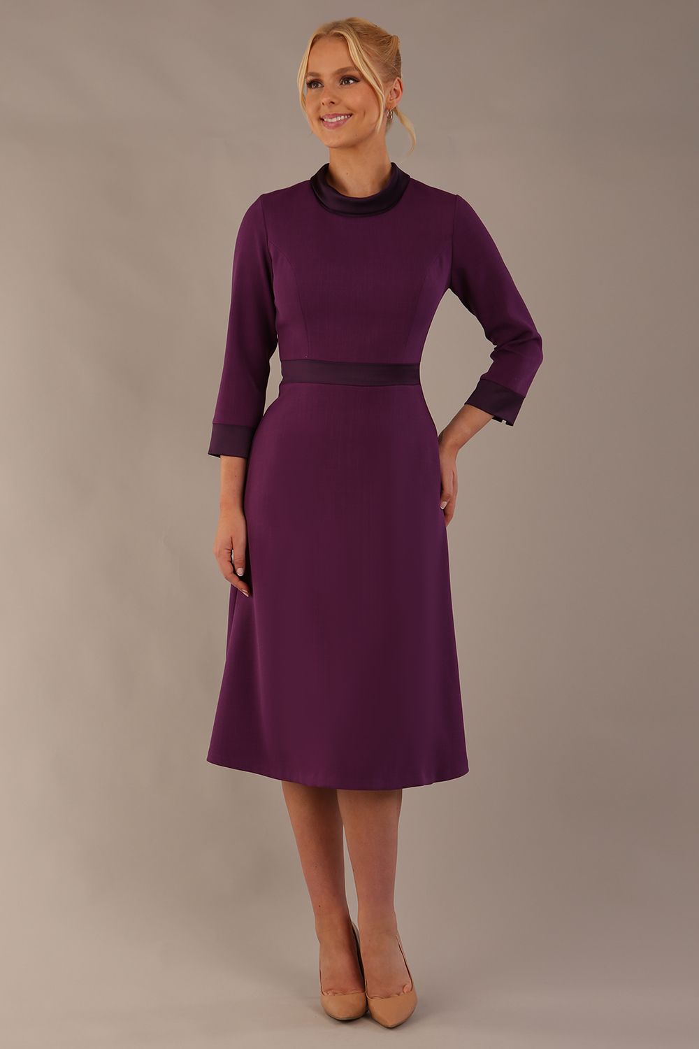 Model wearing the Sybil A-line midi dress in imperial purple with a satin cowl neck and waistband (Imperial Purple)