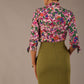 Model wearing a Radley Floral Tango print top with a central tie neckline and 3/4 sleeves, styled with an olive green skirt.