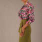 Model wearing a Radley Floral Tango print top with a central tie neckline and 3/4 sleeves, styled with an olive green skirt.