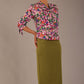 Model wearing a Radley Floral Tango print top with a central tie neckline and 3/4 sleeves, styled with an olive green skirt.