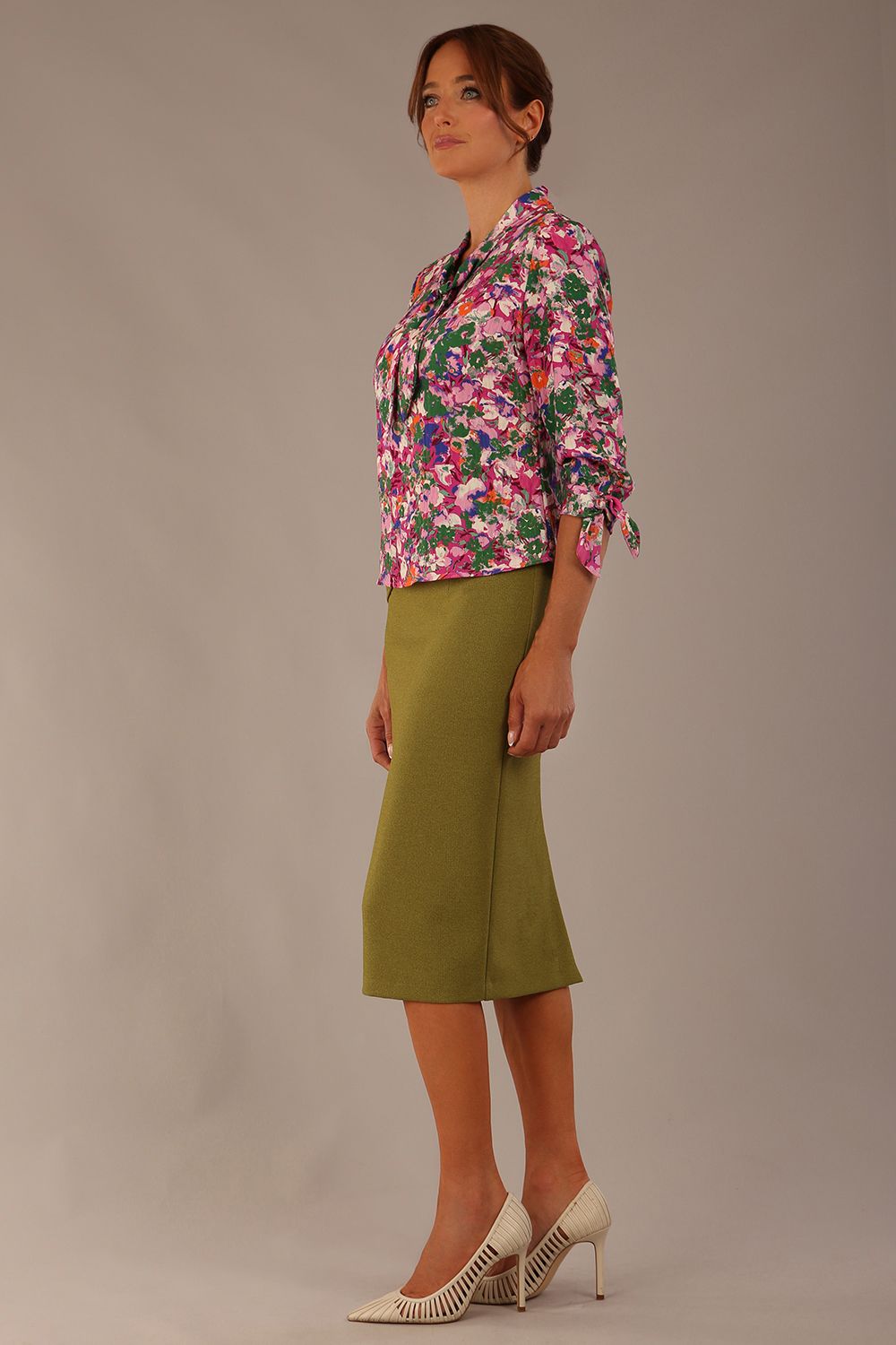 Model wearing a Radley Floral Tango print top with a central tie neckline and 3/4 sleeves, styled with an olive green skirt.
