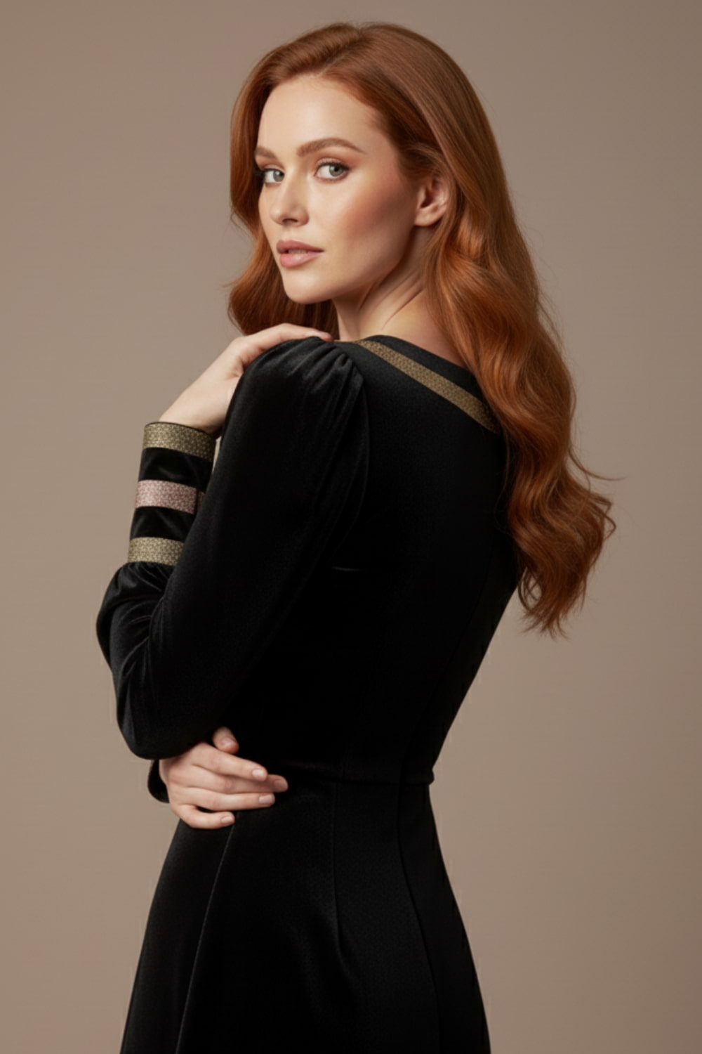 Woman wearing a black dress with sheer sleeves against a beige background  (Black Velvet with Sherwood Glitter Contrast)