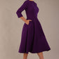 Model wearing the Perpetua A-line dress in deep purple with hands in pockets (Deep Purple)