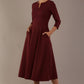 Model wearing the Perpetua A-line dress in wine with hands in pockets (Wine)