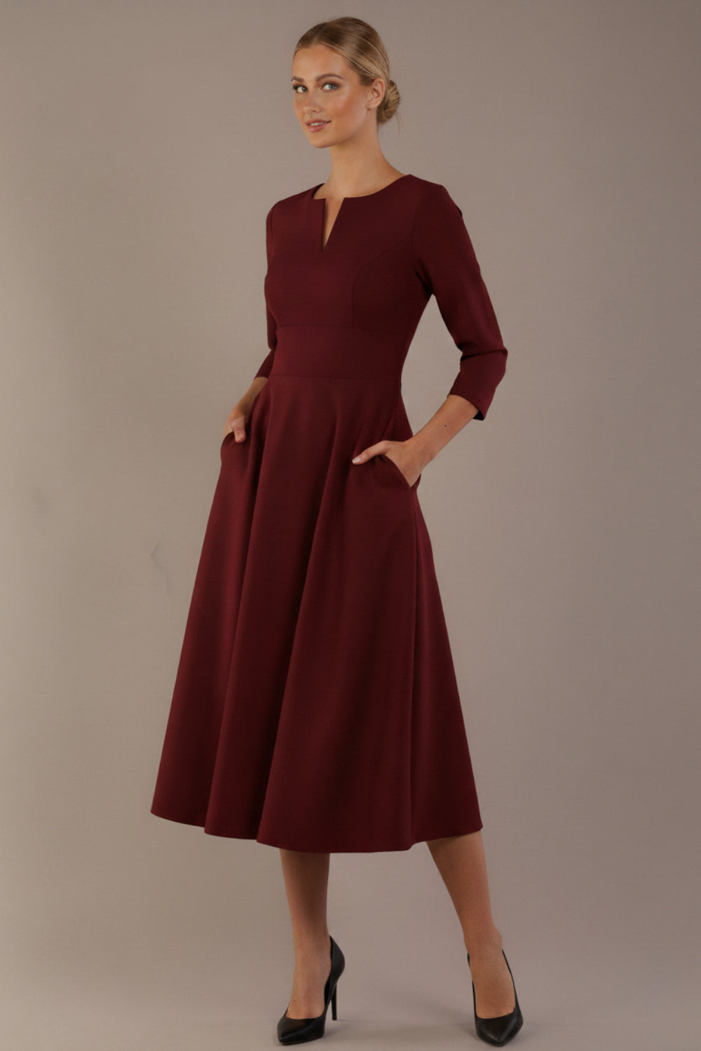 Model wearing the Perpetua A-line dress in wine with hands in pockets (Wine)