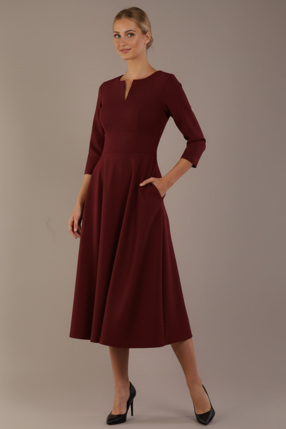 Model wearing the Perpetua A-line dress in wine with a hand in pocket (Wine)