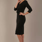 Woman wearing the Corniche double bow pencil dress in classic black against a plain background (Black)
