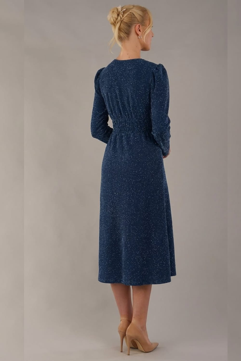 Model wearing the Calvert sparkle A-line dress in burgundy, Back view of the Calvert sparkle midi dress, showing the gathered waistband and clean silhouette. (Teal Sparkle)