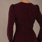Model wearing the Calvert sparkle A-line dress in burgundy, showing the wrap V-neckline Back view of the Calvert sparkle midi dress, showing the gathered waistband and clean silhouette (Burgundy Sparkle)