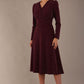 Model wearing the Calvert sparkle A-line dress in burgundy, showing the wrap V-neckline highlighting the fluid A-line skirt and long sleeves (Burgundy Sparkle)