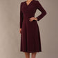 Model wearing the Calvert sparkle A-line dress in burgundy, showing the wrap V-neckline highlighting the fluid A-line skirt and long sleeves (Burgundy Sparkle)