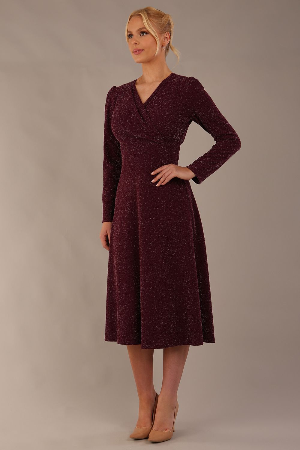 Model wearing the Calvert sparkle A-line dress in burgundy, showing the wrap V-neckline highlighting the fluid A-line skirt and long sleeves (Burgundy Sparkle)
