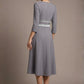 Back view of the model wearing the Seed Alisa dress, showcasing the sharp V-notch neckline, flawless tailoring, and luxurious satin contrast detail (Sky Grey - Silver Grey)