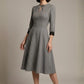 Woman wearing a diva catwalk Alanna Dogtooth Tie-Detail A-Line Dress | Diva Catwalk with long sleeves against a plain background (Petite Dogtooth Check)