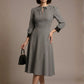 Woman wearing a diva catwalk Alanna Dogtooth Tie-Detail A-Line Dress | Diva Catwalk with long sleeves against a plain background (Petite Dogtooth Check)