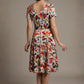 Woman wearing a diva catwalk colorful floral dress called Valia Silk Touch A-Line Dress against a plain background (Erratic Leaf Print)