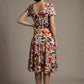 Woman wearing a diva catwalk colorful floral dress called Valia Silk Touch A-Line Dress against a plain background (Erratic Leaf Print)