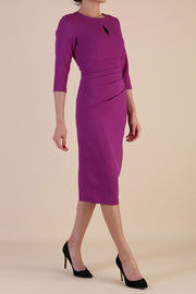brunette model wearing diva catwalk ubrique pencil dress with a keyhole detail and sleeves in hollyhock purple colour front