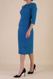 brunette model wearing diva catwalk ubrique pencil dress with a keyhole detail and sleeves in teal colour front