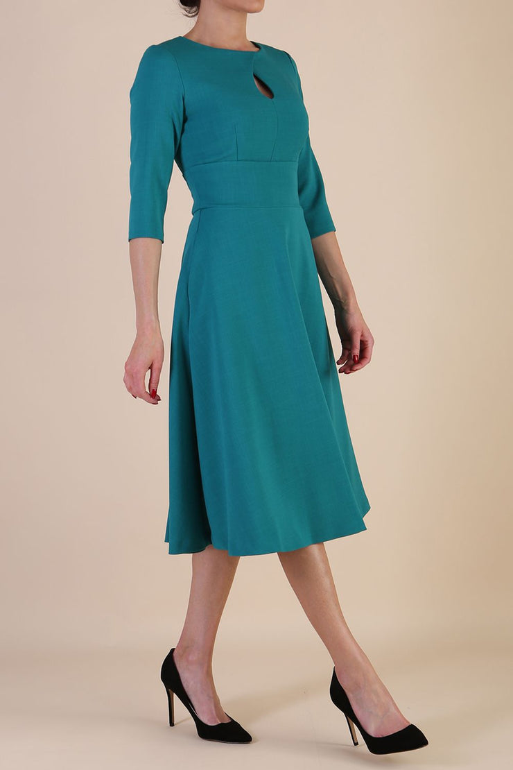 Brunette model is wearing diva catwalk casares swing dress with a keyhole neckline three quarter sleeve dress with pocket detail in parasailing green front side