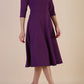 Brunette model is wearing diva catwalk casares swing dress with a keyhole neckline three quarter sleeve dress with pocket detail in imperial purple side front