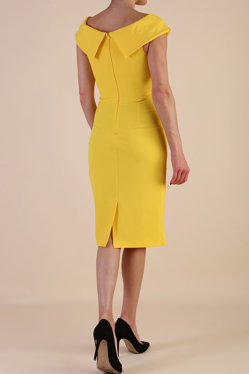 brunette model wearing diva catwalk evening pencil skirt dress sleeveless with lowered neckline and pleating on side in yellow colour front