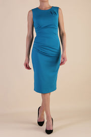  model wearing diva catwalk primula pencil skirt dress in pink with pleating on one side and sleeveless design in colour Magic Blue