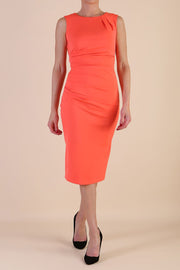  model wearing diva catwalk primula pencil skirt dress in pink with pleating on one side and sleeveless design in colour Hot Coral