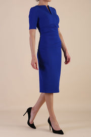 model is wearing Diva Catwalk Lydia Short Sleeve Pencil Dress with pleating across the tummy and split neckline in Cobalt Blue