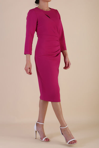 model is wearing diva catwalk miracle pencil dress with keyhole detail on a side of the front panel and gathering detail on a side or bodice panel with sleeves in magenta haze colour front