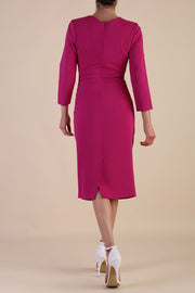 model is wearing diva catwalk miracle pencil dress with keyhole detail on a side of the front panel and gathering detail on a side or bodice panel with sleeves in magenta haze colour front